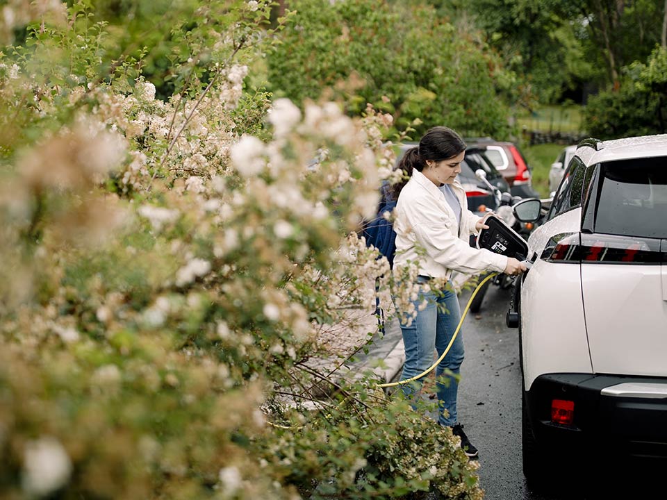 Fotograf: Maskot bildbyrå
Bildbyrå: Johnér Kvinna står utomhus och kopplar in laddare till elbil, Stockholm