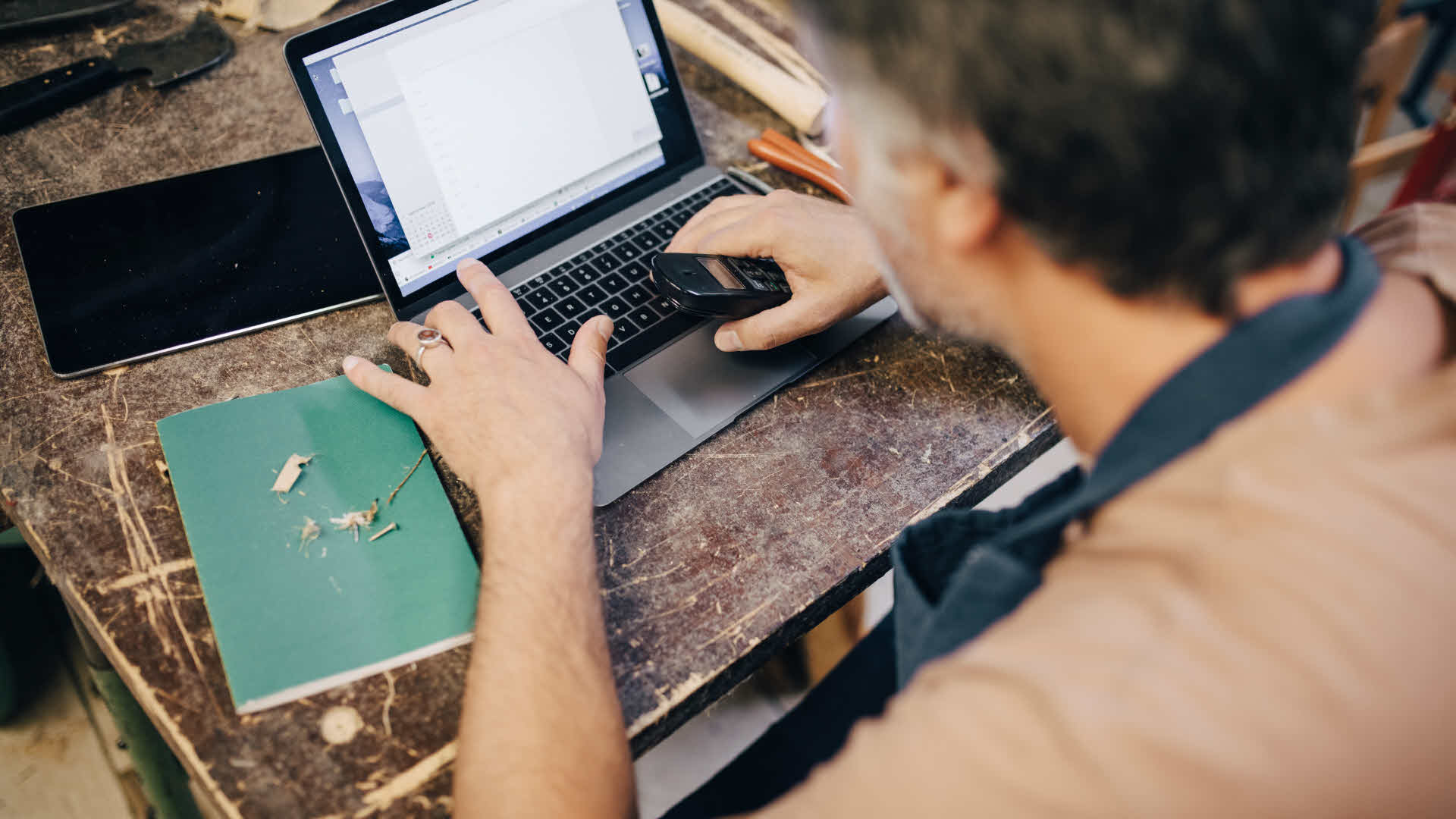 Man skriver på sin laptop i en verkstad