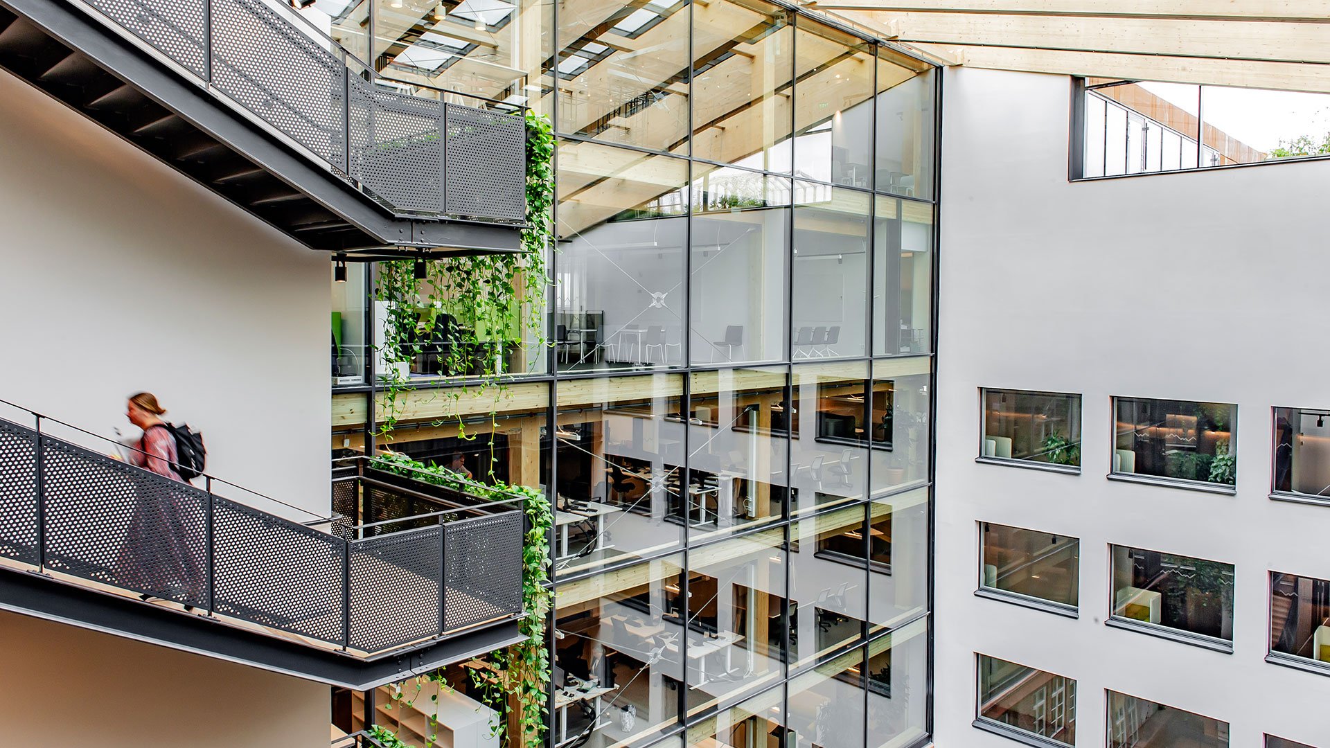 En person med ryggsäck går i en trappa på Naturvårdsverkets kontor i Stockholm. 