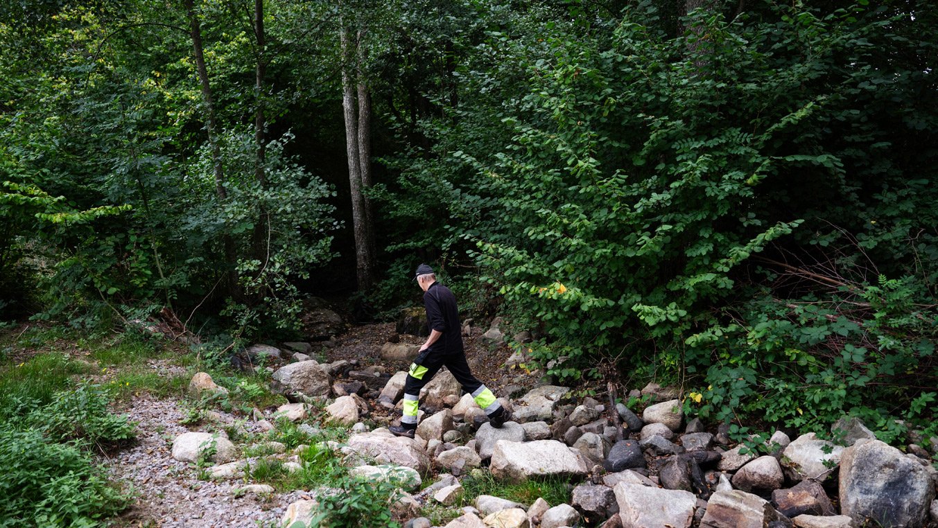 Man som balanserar på stenbumlingar i naturen