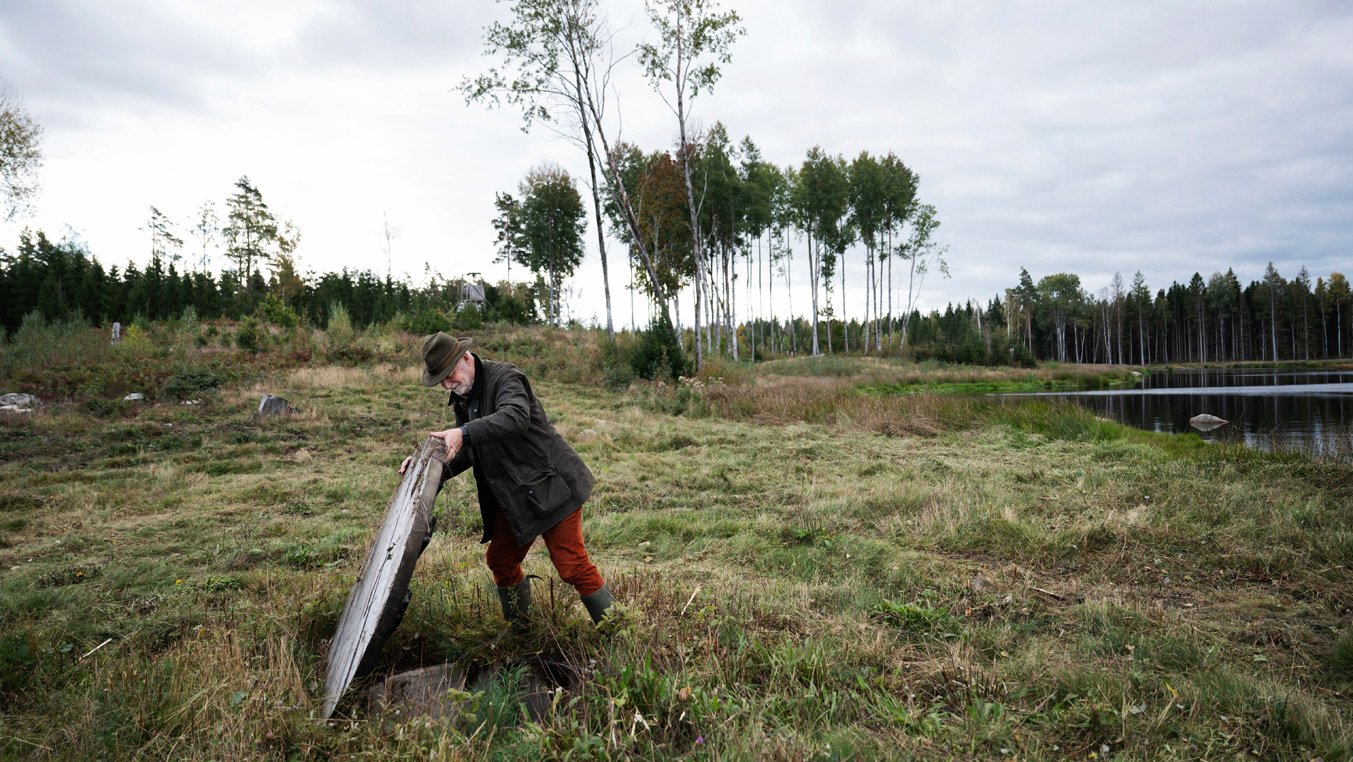 Man lyfter upp en tung skiva på mark