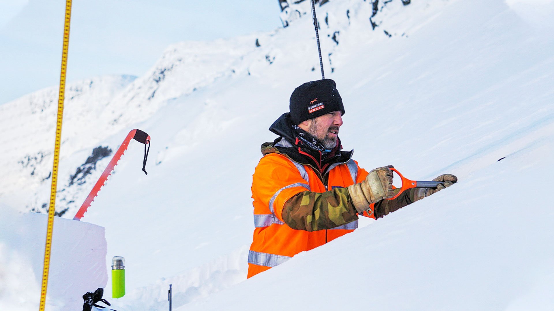 En fjällvakt mäter lavinfaran i snölagren.